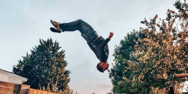 Kacper, Customer Support Executive, performing a back flip. 